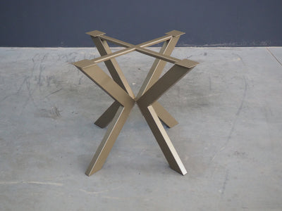 A BRONZE metal table base designed for supporting a round table top, displayed on a wooden floor against a white background.